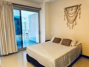 A bedroom with a bed, a sliding glass door, and a wall-mounted decorative item.