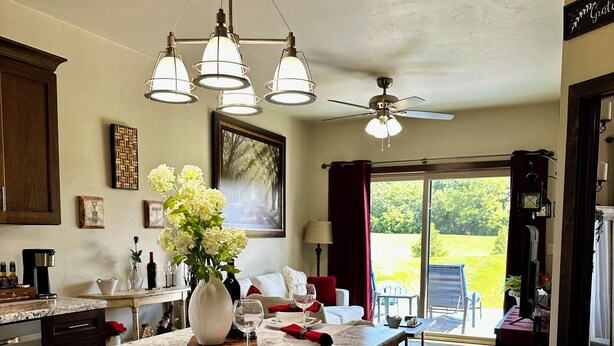 Une cuisine dotée d’un grand îlot central, de luminaires suspendus et d’un ventilateur de plafond.