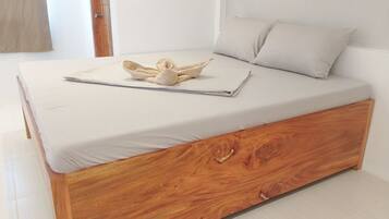 A single bed with a wooden frame and a white mattress.
