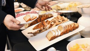 Een buffet met diverse soorten eten, waaronder brood en gebak.