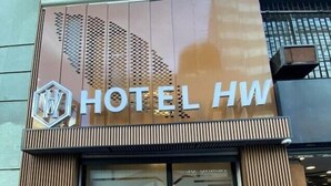 Een hotelgevel met een opvallend bord waarop 