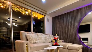 Un salon moderne avec un canapé d’angle, une petite table ronde et un jouet décoratif posé sur la table.
