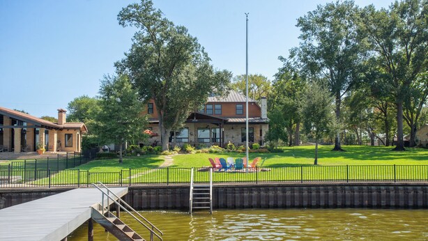 A riverside walkway with a wooden dock and a metal staircase leading into a body of water.