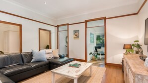 A modern living room with a leather sofa, a coffee table, and a wooden cabinet.