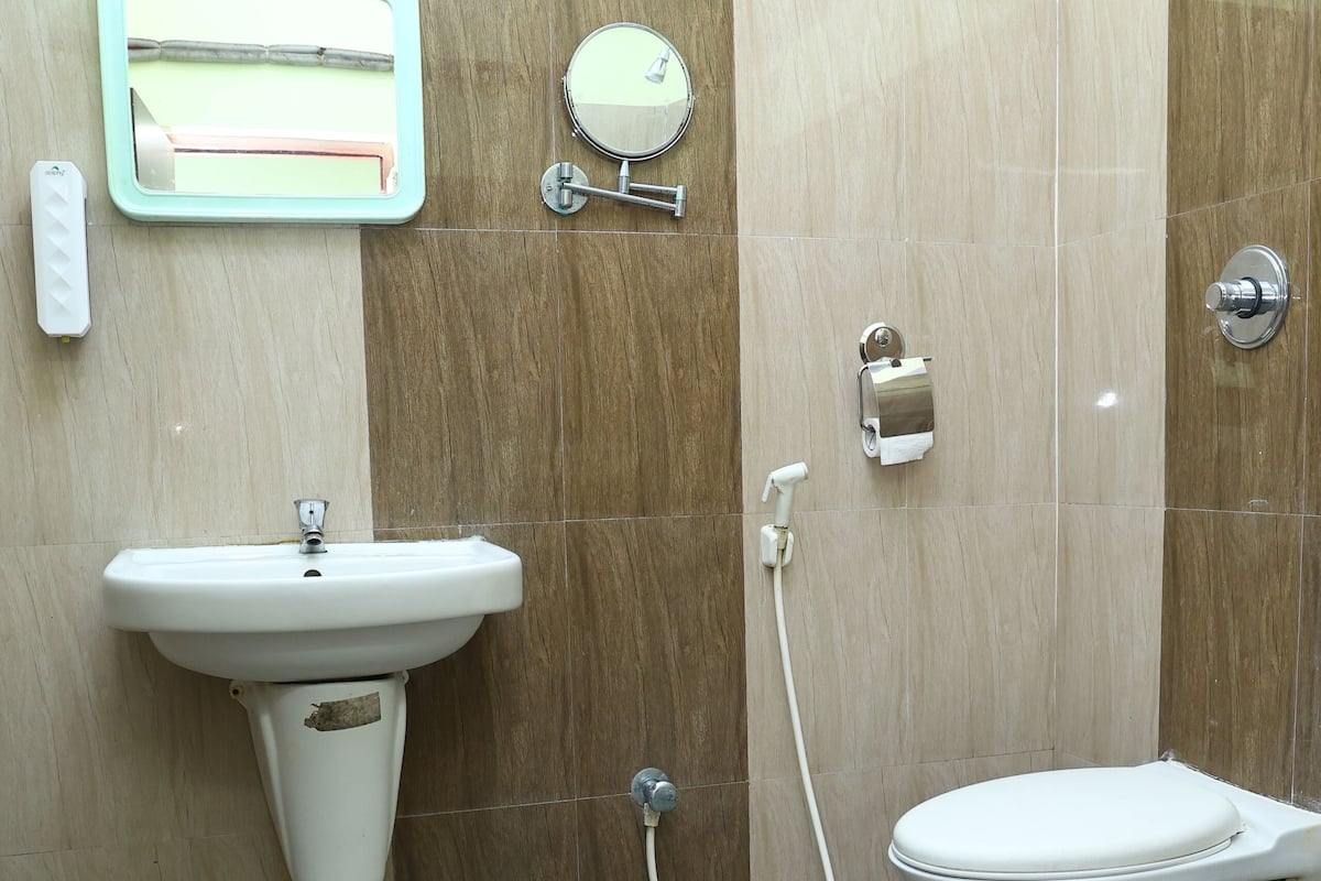 A bathroom with a sink, toilet, and a mirror.