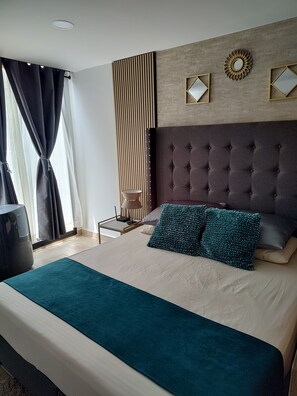 Relax in a spacious room with a large bed, tufted headboard, and comfortable seating area.