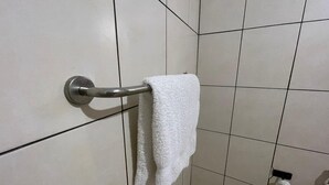 A bathroom with a towel rack holding a white towel. - Home Investments Villa (Moshi)
