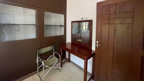 A room with a sliding door, a small table, and a chair. - Home Investments Villa (Moshi)