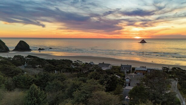 A coastal landscape with a sunset, rocky outcrops, and a beach. - Royal Canoe by Avantstay Walk to the Shore + Cozy Fireplace (Arch Cape)