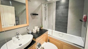 A modern bathroom with a sink, toilet, and shower. - 2 Bed flat w/ AC by Trafalgar square & London eye (London)
