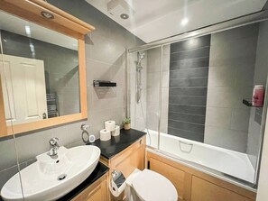 A modern bathroom with a sink, toilet, and shower.