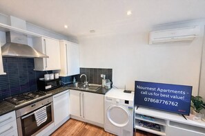 A modern kitchen with a stove, oven, microwave, sink, and a washing machine.