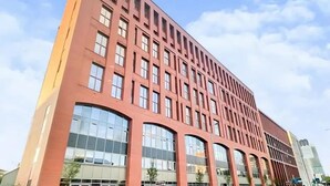 Ein mehrgeschossiges Gebäude mit modernem architektonischen Design, große Fenster und ein Flachdach.
