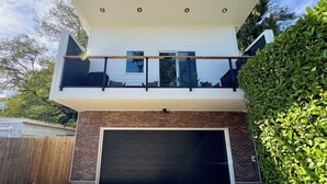 Una moderna casa a due piani con garage, balcone e facciata in mattoni.