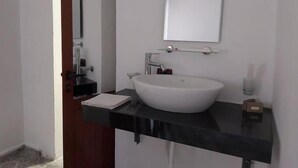 A modern bathroom with a white sink, a black countertop, and a mirror above the sink. - Through Mangalem (Berat)