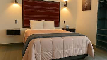 A modern bedroom with a large bed, two bedside tables, a wall-mounted TV, and a built-in wardrobe.