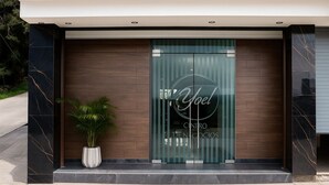 Entrada moderna de un edificio con puerta de vidrio que muestra el nombre "Joel Centro de Negocios".