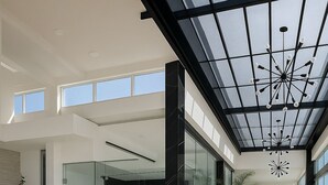 Un interior espacioso con techo alto, ventanas grandes y diseño moderno.