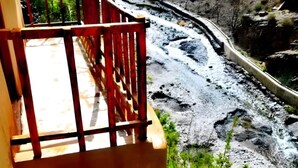 A wooden deck with a railing overlooking a river. - dar awlim (Imilmaiss)