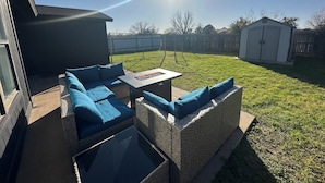 A patio with a sofa and a table, a small shed, and a fenced yard. - Luxury Lane: Pet & Family Haven Near ASU & GF Base - Stock Show 7 mi - No Stairs (San Angelo)