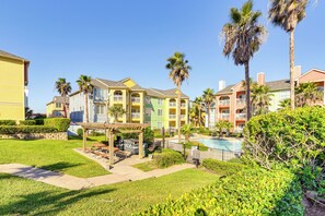 Un barrio residencial con casas coloridas, una piscina y jardines bien cuidados.