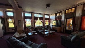 Amplia sala de estar con chimenea, ventanas grandes y un rincón de estar acogedor.