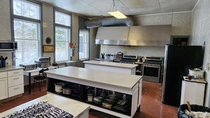 Una cocina moderna con armarios blancos, electrodomésticos de acero inoxidable y una isla grande.