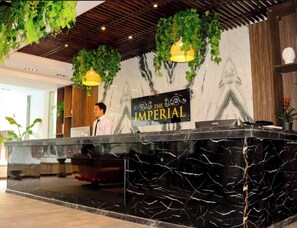 A reception desk with a marble top, a sign reading "The Imperial", and hanging greenery. - Sea View Suite Sleeps 2 With Parking (Hurghada)