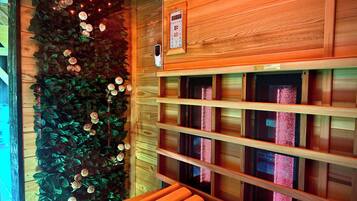 A wooden interior with a wall-mounted shelf unit and a decorative wall with artificial flowers and lights.
