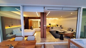 Een moderne hotelkamer met een zithoek, een woonkamer met een zette en een keukenhoek.