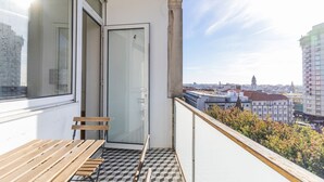 A balcony with a wooden bench, a glass door, and a patterned floor. - 2BR Wonder in the City Center by LovelyStay (Porto)