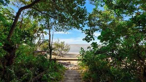 A wooden pathway leading to a beach through a forested area. - Rooftop Tranquility at Stunning Temple Resort (Craiglie)