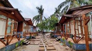 A row of wooden cabins with a central staircase leading to a higher level. - Shurjo Snan Twin Beach Resort (Saint Martin's Island)