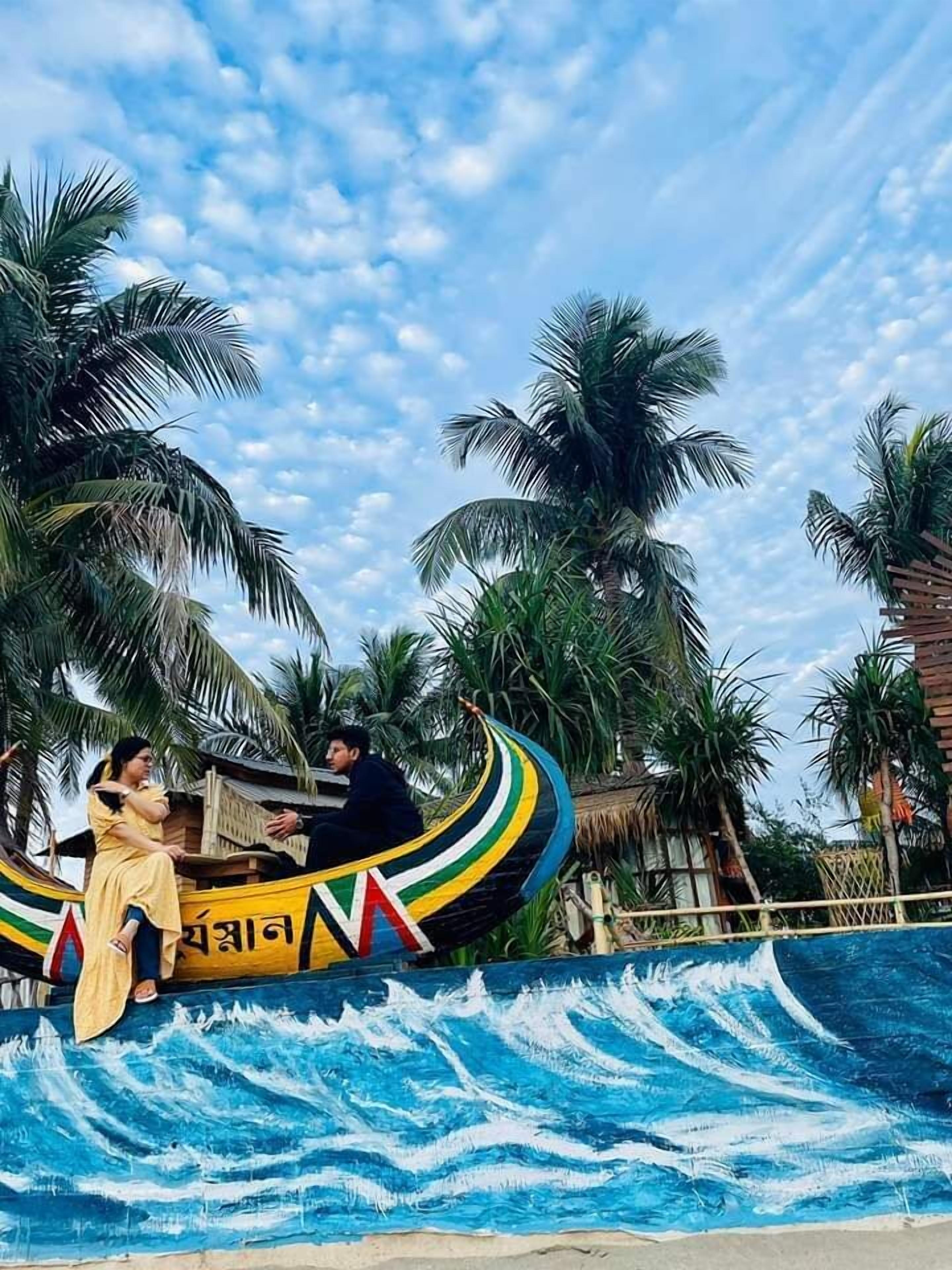 A boat ride with passengers, surrounded by palm trees and a painted wave design on the water.