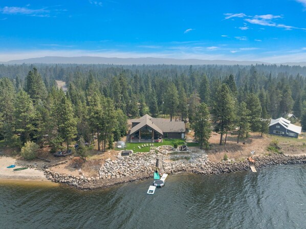A lakeside cabin with a stone dock, surrounded by dense forest. - -Lakehouse Trampoline-Hot Tub-Sauna-Climbing Wall (Donnelly)