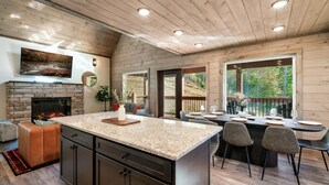 Una cocina moderna con una isla grande, techo de madera y chimenea.