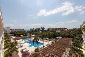 A resort with a swimming pool, lounge areas, and a view of the ocean. - Magia by Zamá Homes (Playa del Carmen)