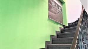 Una scala con un muro verde e un quadro incorniciato.