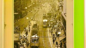 Un corridoio con un murale che raffigura una scena di strada d’epoca, con tram e pedoni.