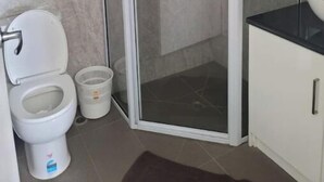 Ein Badezimmer mit Toilette, Duschkabine und Waschbecken.