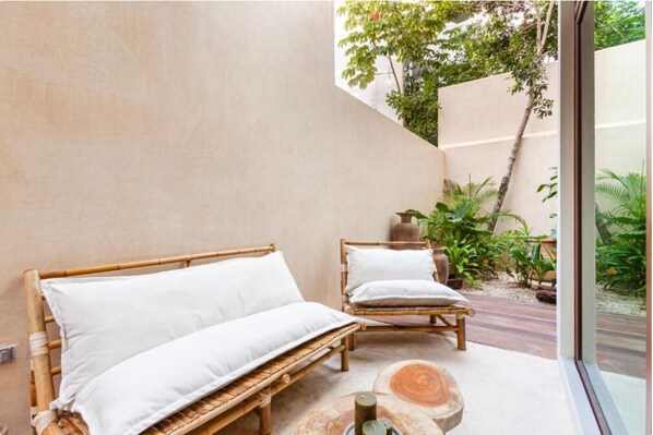 A room with two wooden beds and a large window overlooking a garden. - Azalea by Zamá Homes (Tulum)
