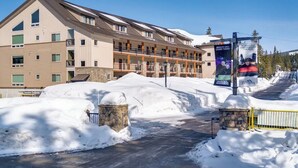 A multi-story hotel with balconies, a stone entrance, and a snow-covered driveway. - Government Camp Condo: Ski-in/Ski-out, Mountain Views, Walk to Downtown (Government Camp)