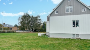A modern two-story house with a sloped roof, a small balcony, and a well-maintained lawn with outdoor furniture. - Stunning home in Sölvesborg with house sea view (Sölvesborg)
