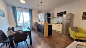 A compact living space with a dining area, kitchen, and seating. - Mirvana Apartments Metheor Executive Suite (Timișoara)