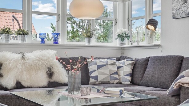 A cozy living room with a glass coffee table, grey sofa, and decorative pillows. - Awesome home in Hirtshals with sauna (Hirtshals)