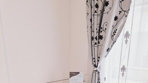 A dining area with a white table, blue chairs, and patterned tablecloths. - Mirvana Apartments Allure Studio (Timisoara)