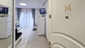 A hotel room with a bed, a TV, and a door with the number 14. - Mirvana Apartments Allure Studio (Timisoara)