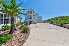 Une grande maison à plusieurs étages, dotée d’un porche à l’avant et d’une allée.