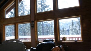 A cabin interior with large windows, a wooden ceiling, and a view of snow-covered trees. - Close to Lake, High Ceilings, Huge Balcony. 2200SF

 (Big Bear Lake)