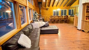 A spacious living area with a wooden ceiling, a black leather sofa, and a Christmas tree. - Close to Lake, High Ceilings, Huge Balcony. 2200SF

 (Big Bear Lake)